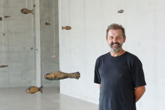 The photo shows Ugo Rondinone next to his 48 bronze fishes at the Belvedere of Museum Würth 2 in Künzelsau. 